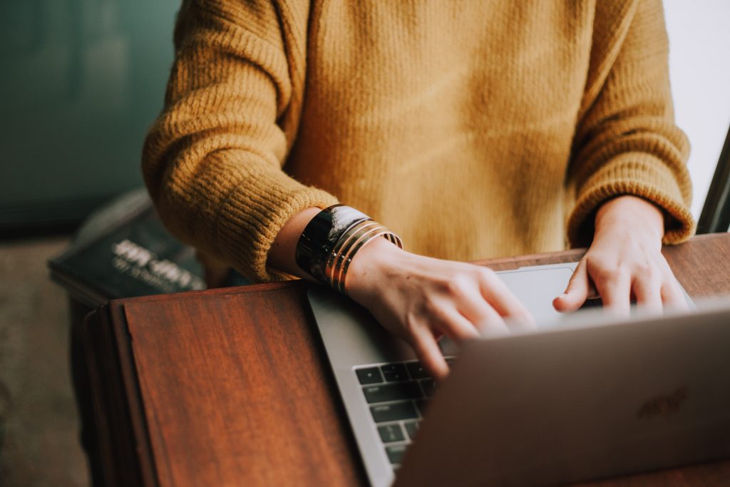 Person participating in the Publish Your Purpose 30-day book writing challenge using laptop computer to write book.