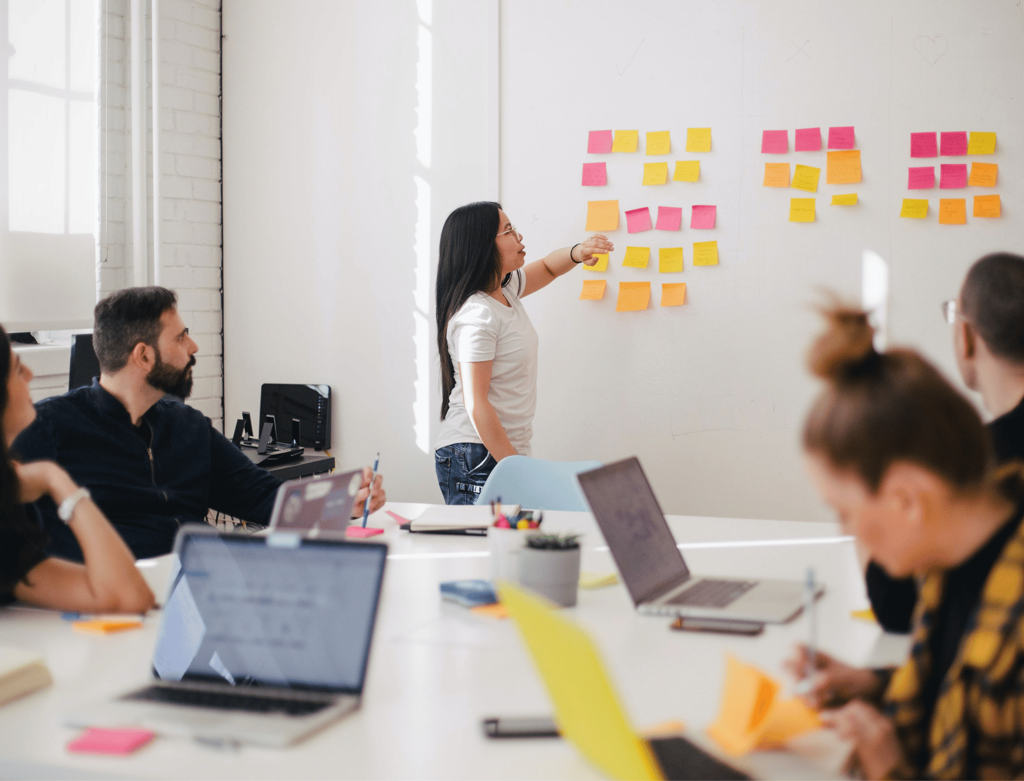 Woman placing sticky notes on a wall. Get book marketing guidance from Publish Your Purpose.