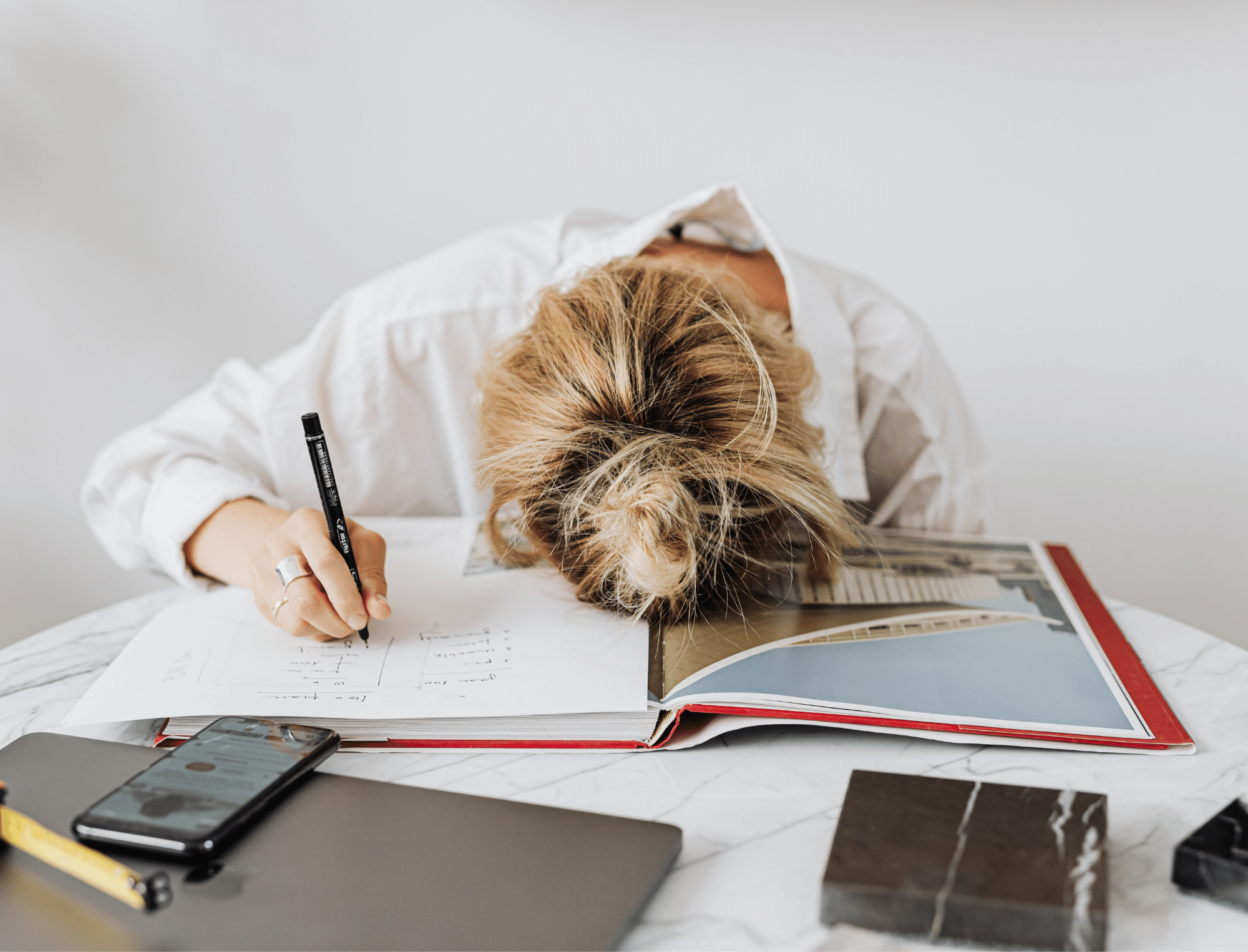 Woman with head on desk. Learn how to overcome writer procrastination with Publish Your Purpose.