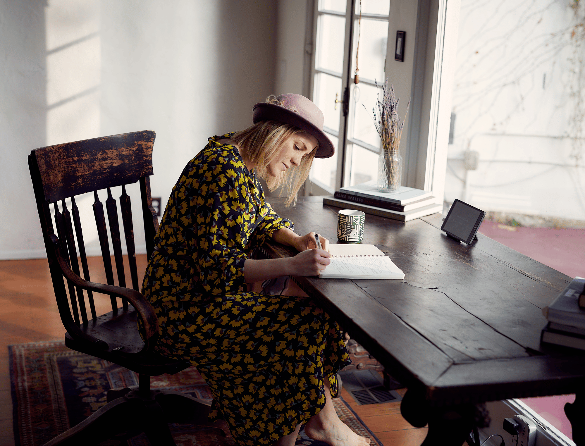 Woman sits at a desk writing. Learn how to develop your writing mindset with Publish Your Purpose.